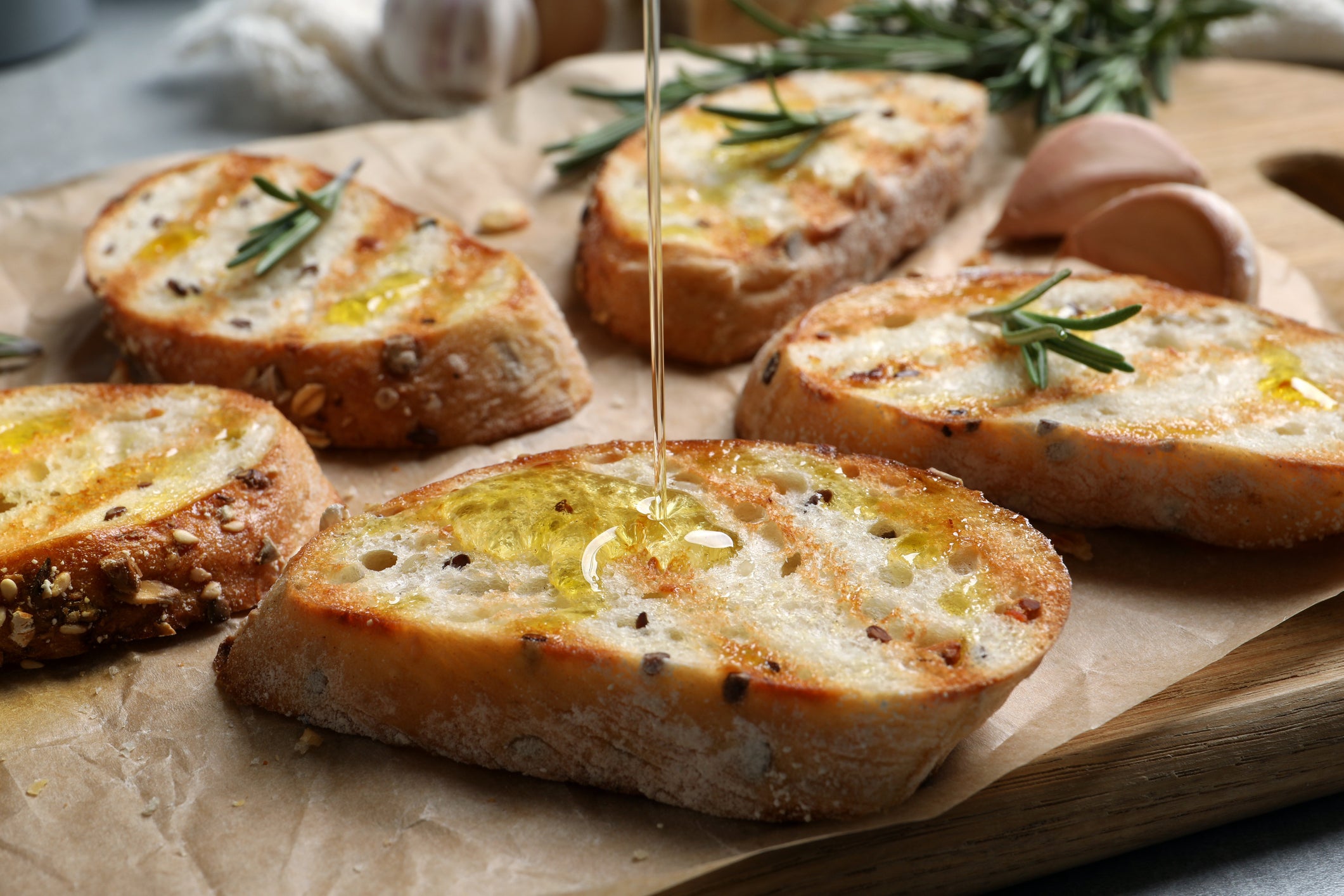 Image of Olive oil being poured on french baquette